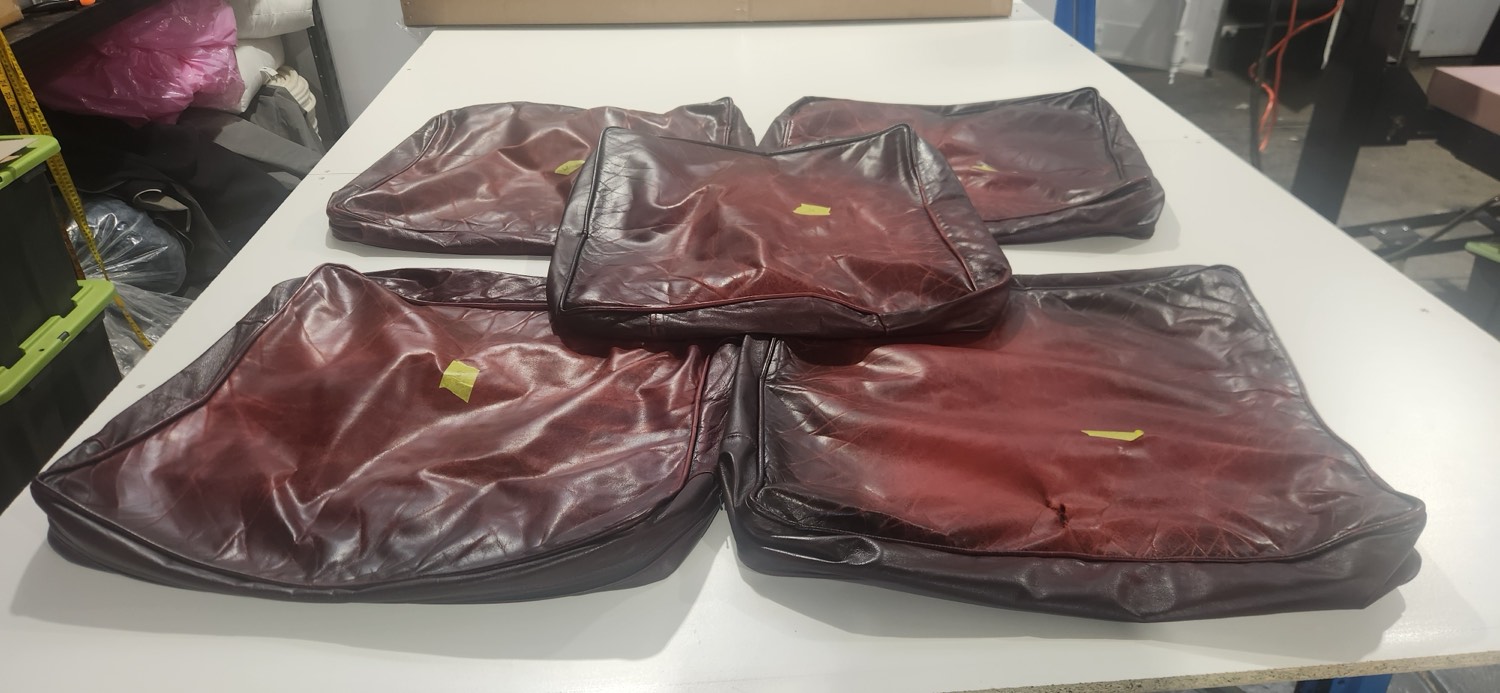 Worn original Moran Chesterfield seat cushion covers, creased and marked after decades of use, before reupholstery