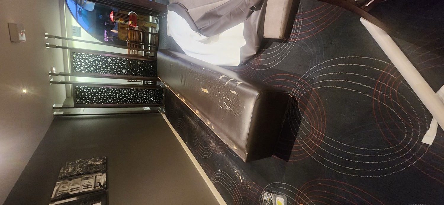 Worn and peeling vinyl banquette seat at the Veneto Club in Bulleen before recovering, with the new cover laid out ready